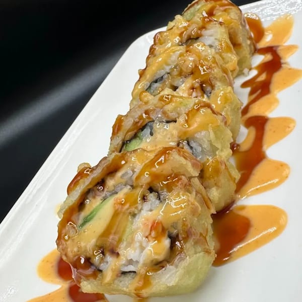 Sushi Fever's fried sushi roll with avocado, rice, and a drizzle of sweet and spicy sauces.