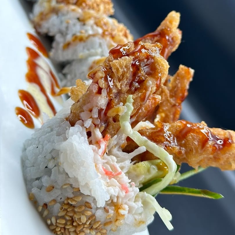 Sushi Fever's soft shell crab roll with sweet sauce, crab meat, and sesame seeds.